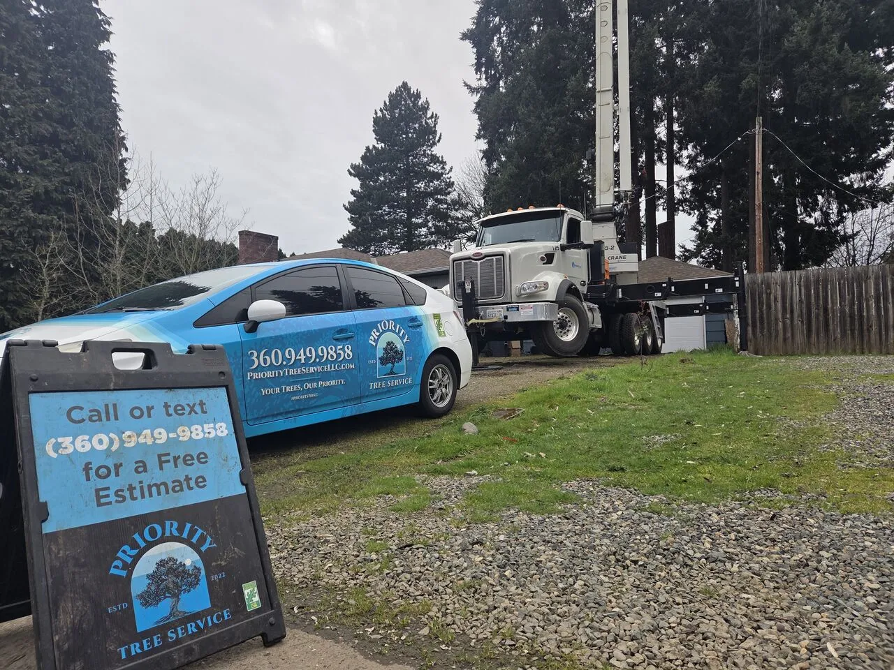 Priority Tree Service car, estimate sign and crane truck parked at a Felida, WA residential job site